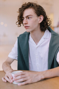 Boy with decisive look resting in cafe