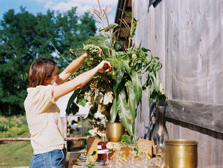 Woman fixing an organic flower arrangement for a garden party