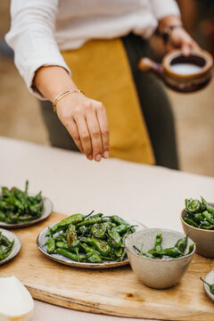 Putting salt on roasted green peppers