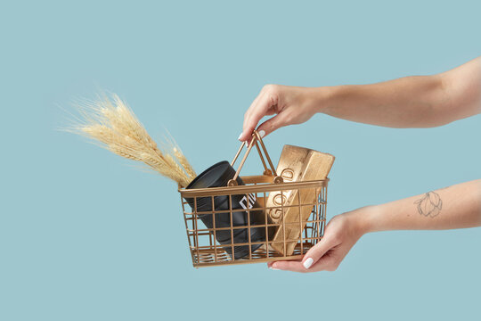 Wheat, oil and gold in basket held by woman.