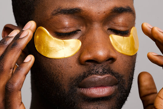 Man using gold eye patches close up
