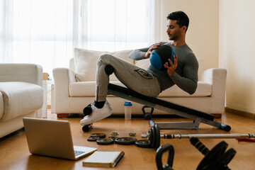 Sportsman doing oblique twist on bench