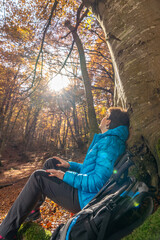 Fototapeta premium Young woman enjoying the fall colors among beech trees in October.