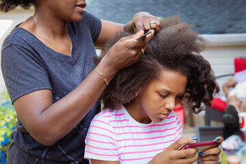 Mother combing her child's kinky curly coily hair
