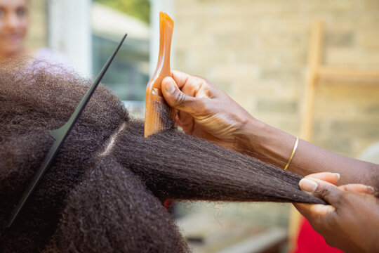 Mother combing her child's kinky curly coily hair