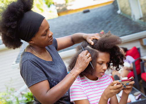 Mother combing her child's kinky curly coily hair