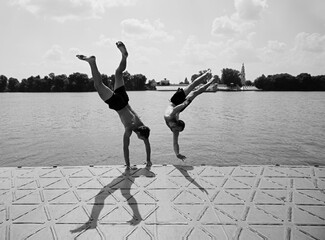 Two young guys doing somersaults into the water