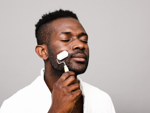 Man enjoying spiked roller facial massage