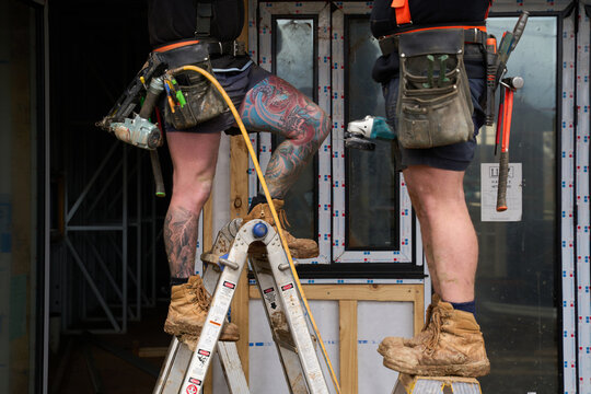 Tradesmen working together at residential home building site