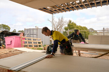 Tradies at worksite cutting cladding boards