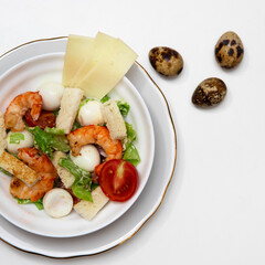 Warm salad with vegetables and cream sause and shrimps. Isolated on a white background.