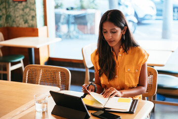Female manager checking notes in planner