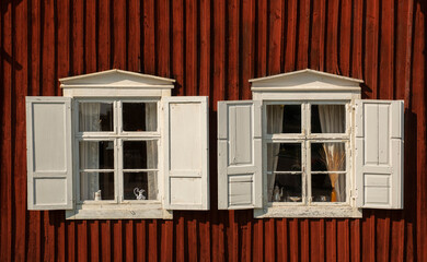 Red facade with two white windows. 