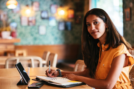 Freelancer making notes in cafe