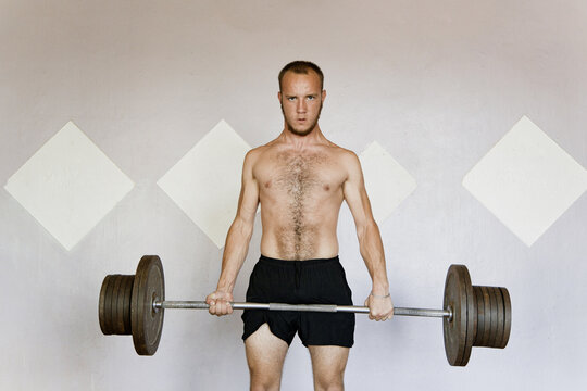 Serious male athlete with barbell