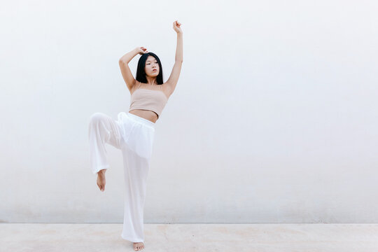 Asian female dancer with raised knee
