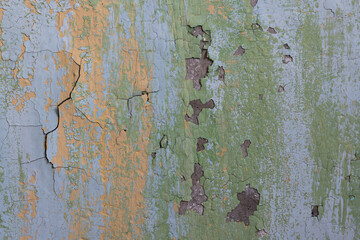 Peeling paint on the wall. Old concrete wall with cracked flaking paint. Weathered rough painted surface with patterns of cracks and peeling. Grunge texture for background and design. High resolution.
