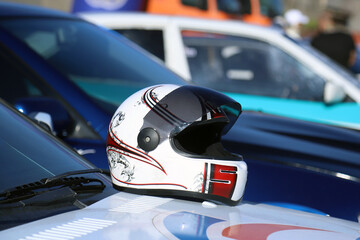 Fototapeta premium Racer helmet on the hood of a sports car. Shallow depth of field