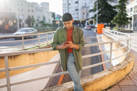 young black man with mobile phone outdoors