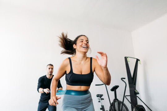 Woman Running in Gym with Resistance Band 