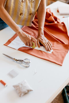 A woman&rsquo;s hands mark a pattern with chalk