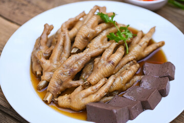chicken feet soup stewed, cooking chicken feet foot stew on white with herbs and spices ingredients with chilli lemon vegetable on wooden background, Asian chinese food menu stew - Thai food