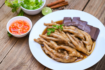 chicken feet soup stewed, cooking chicken feet foot stew on white with herbs and spices ingredients with chilli lemon vegetable on wooden background, Asian chinese food menu stew - Thai food