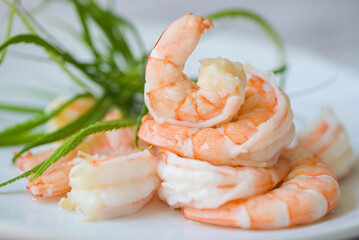 Fresh shrimp on white plate, cooked shrimps prawns for seafood with herb cannabis leaf, cooking boiled shrimp - obrazy, fototapety, plakaty