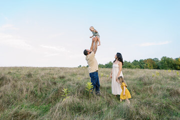 Family in a field of tall grass together outdoors