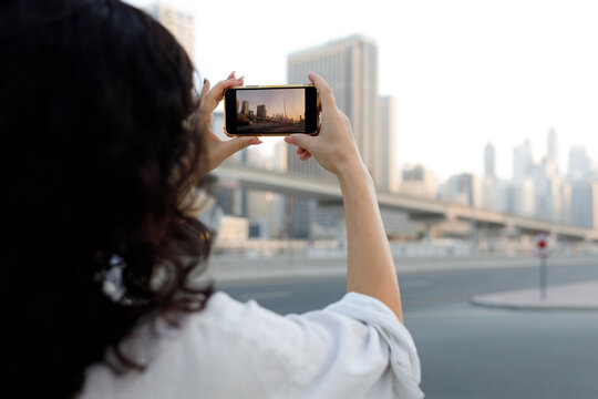 A woman taking picture of Dubai city