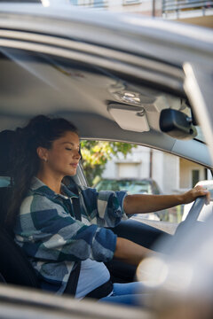 View of pregnant woman start engine from outside car