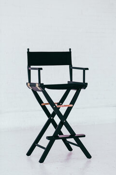 Black director's chair in a bright and airy white brick warehouse