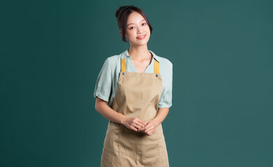 portrait of Asian woman wearing apron on green background