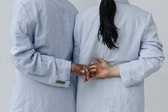 Two people linking hands in blue outfits