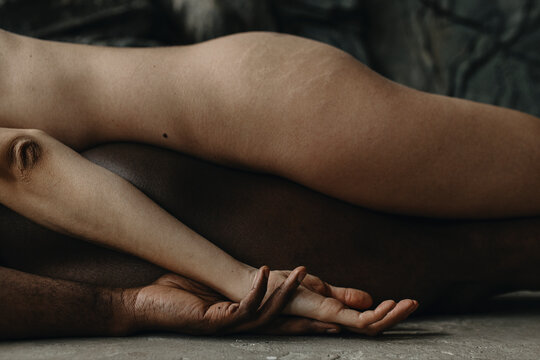 Photo of Multiethnic Love Couple With Hand In Hand lying on ground


