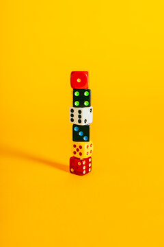 Colorful dice pieces on a vibrant yellow background