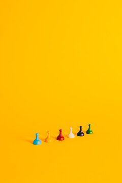Colorful Board Game pieces diagonally on a vibrant yellow background