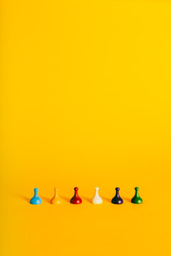 Colorful Board Game pieces horizontally on a vibrant yellow background