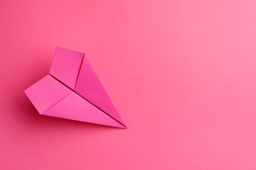 Handmade paper plane on pink background, top view. Space for text