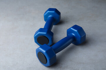 Blue vinyl dumbbells on light grey table