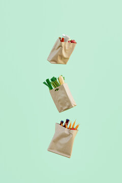 Shopping: Paper bags full of groceries floating on green background