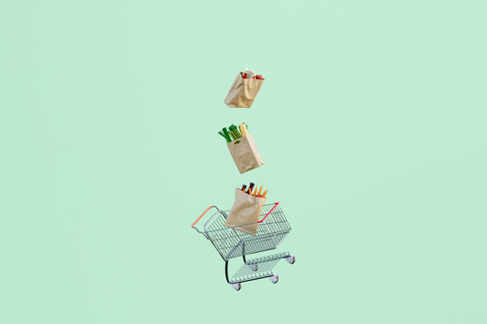 Paper bags filled with groceries floating over shopping cart