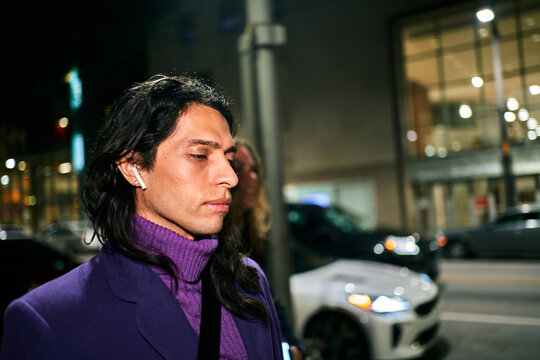 stylish hispanic male walking at night