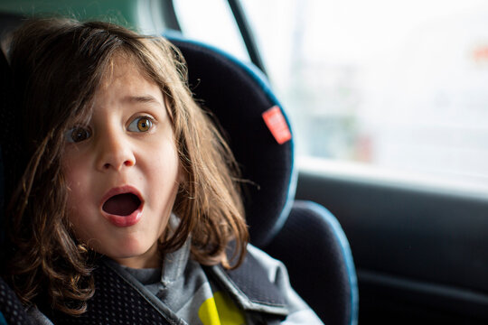 Portrait of a five year old boy sitting in a carseat