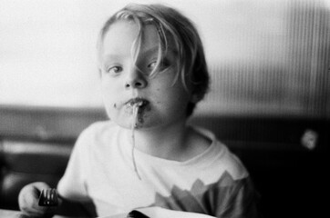 a blond boy eating pasta