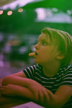 A boy eating breadstick in a bar