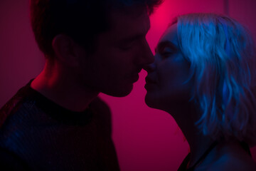 Cinematic lovers kiss with neon lighting