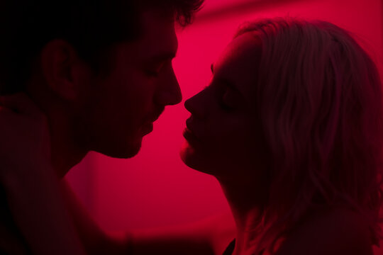 Lovers silhouettes about to kiss at night club
