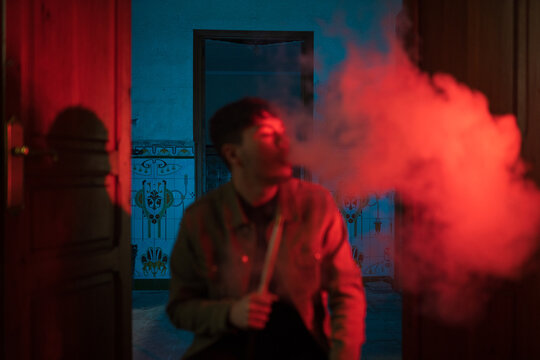 Male smoking hookah against ornamental wall