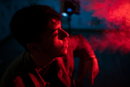 Young man smoking at night